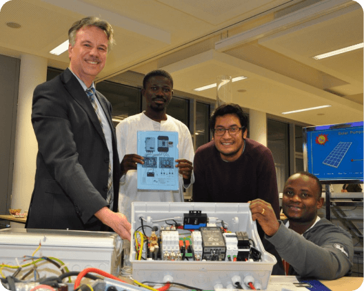 Students showing an electric installation in a solar energy entepreneur course